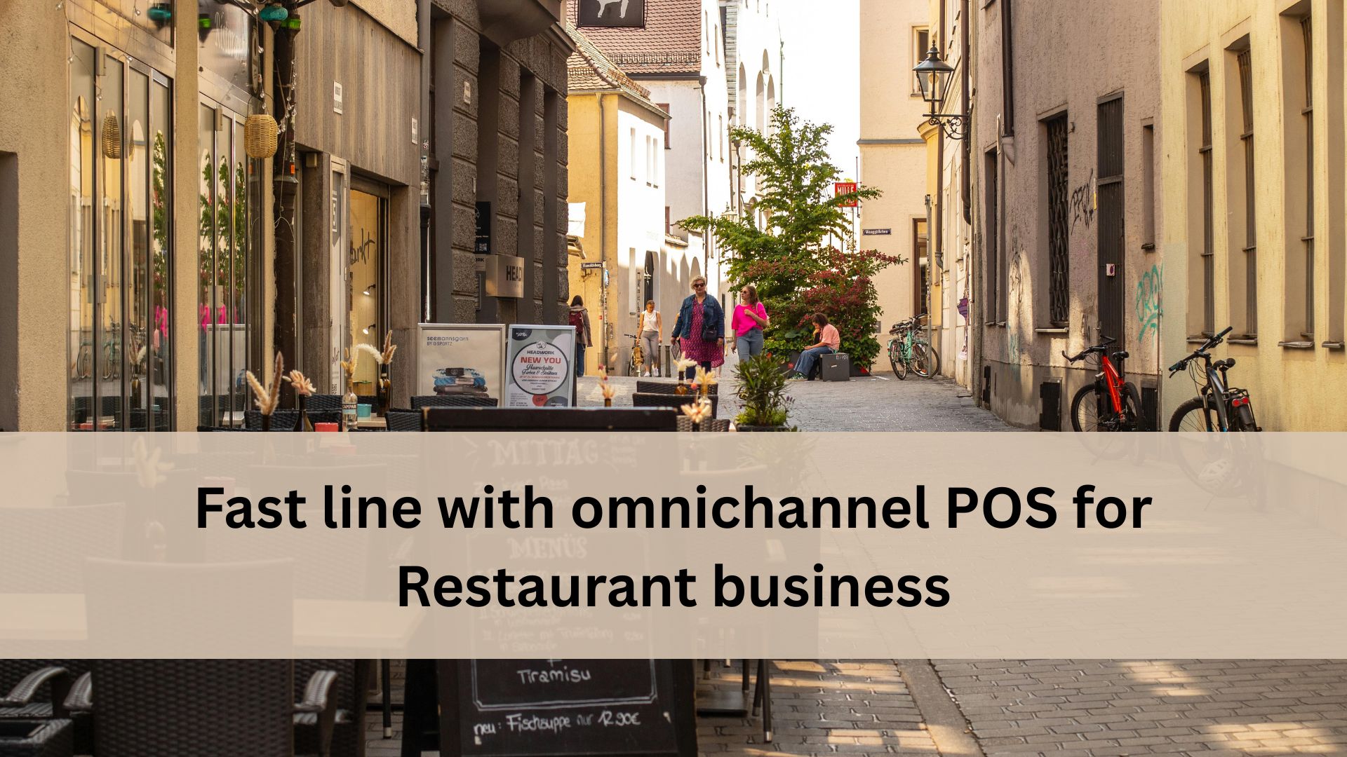 Outdoor restaurant seating along a narrow street with people walking, bicycles nearby, and a banner that reads “Fast line with omnichannel POS for restaurant business