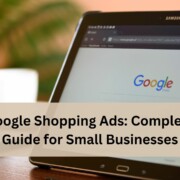 A tablet showing the Google search homepage on a table with a coffee cup in the background, with text overlay reading “Google Shopping Ads: Complete Guide for Small Businesses”