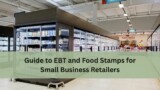 Grocery store aisle with large refrigerated cases filled with food items, with text overlay that reads “Guide to EBT and Food Stamps for Small Business Retailers.”