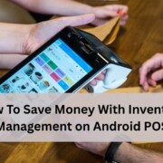 A person holding an Android handheld POS device showing a menu screen while others sit at a wooden table, illustrating inventory management on a mobile point of sale system.