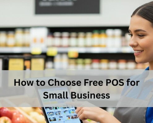 A grocery store employee in a blue uniform smiles while using a free POS system in front of produce and shelves