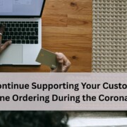 Person using a laptop while holding a credit card, representing online ordering and remote customer support during the coronavirus pandemic.