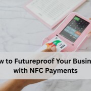 A customer taps a contactless card on a pink NFC payment terminal while another person points at the device screen