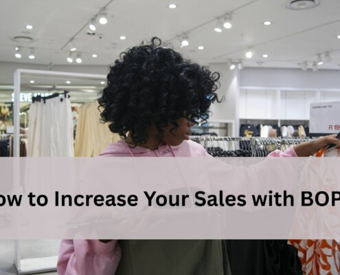 shopper in a clothing store looking at an orange and white patterned top.