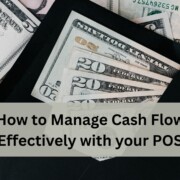 An open black envelope filled with US dollar bills, including twenties, tens, and fives, spread out on top of a larger pile of cash