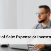 Blurred view of a man working at a desk with a laptop, representing the question of whether a POS system is an expense or an investment