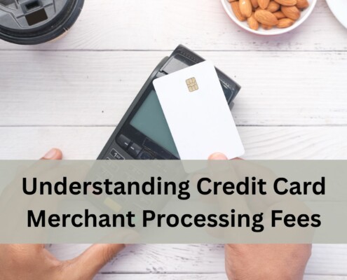 A person holds a payment terminal in one hand and taps a white credit card with the other.