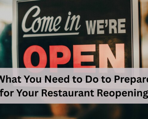 A close up of a storefront sign that says "Come in We're Open" with a blurred restaurant interior in the background.