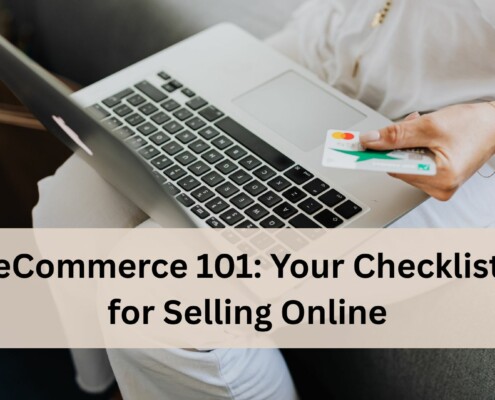 A person sitting on a couch using a laptop while holding a credit card in one hand, ready to make an online purchase